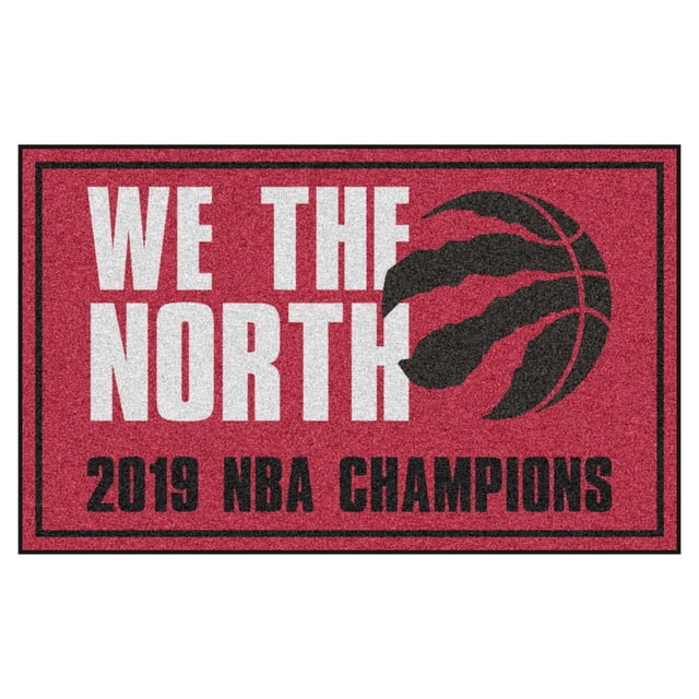 Fanmats NBA Champion Toronto Raptors 5X8 Rug in red 32 oz nylon featuring 'WE THE NORTH' in white, a black basketball claw logo, and '2019 NBA CHAMPIONS' text, with non-skid backing and durable latex base, suitable for game rooms or media areas.