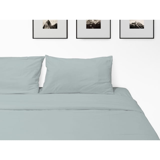 Johnson Home 450 Thread Count Bamboo Bed Sheet Set in light grey, displayed on a neatly made bed with two matching pillowcases, set against a white wall with three framed black and white mountain photographs, featuring breathable, wrinkle-resistant bamboo fabric for year-round comfort.