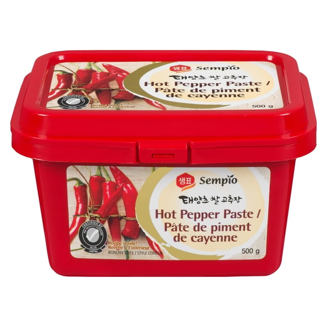Sempio Hot Pepper Paste 500g in a red rectangular plastic container with snap-on lid, featuring a label with red chili peppers and bilingual English-French text. This Korean fermented chili paste is suitable for enhancing stews, marinades, and stir-fries.