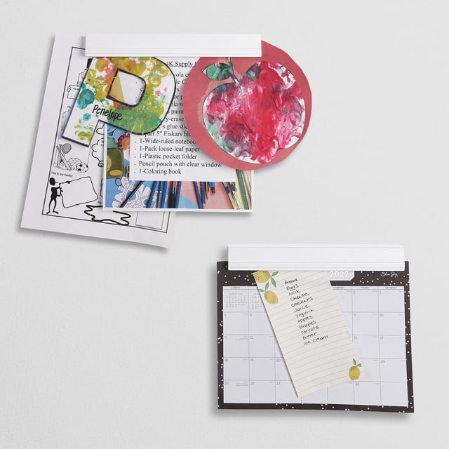 Kids Magnetic Art Bar wall-mounted display with two white magnetic rails holding children's artwork, drawings, a calendar, and a grocery list, serving as a bulletin board alternative for organizing art projects and office notes in playrooms or offices.