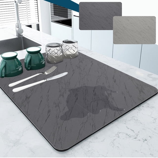 Vaidha Dish Drying Mat Coffee Mat Super Absorbent Drying Mat in black, measuring 12x16 inches, placed on a kitchen counter. Made of foamed diatomite with a rubber back, it features a stylish marbled pattern and is designed for quick water absorption. Shown with cups, glasses, and cutlery on top, highlighting its functionality for drying dishes and protecting countertops.