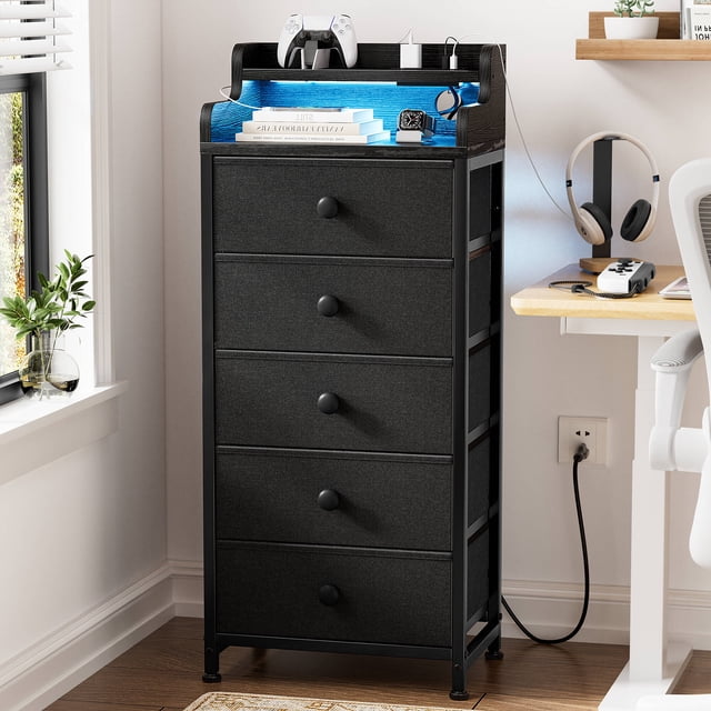 GUNAITO Commode Haute à DEL pour Chambre avec 5 Tiroirs, Dotée d'Un Cadre Mince en Acier Noir, de Bacs de Rangement en Tissu et d'Un Dessus en Bois avec Bord Clôturé. Comprend un Éclairage DEL avec 20 Couleurs, une station de Recharge avec ports USB et Prises, et des Pieds Ajustables pour la Stabilité. Cette Tour de Rangement Compacte Est Idéale pour les Petits Espaces et une Utilisation Polyvalente dans les Chambres Ou les Salons.