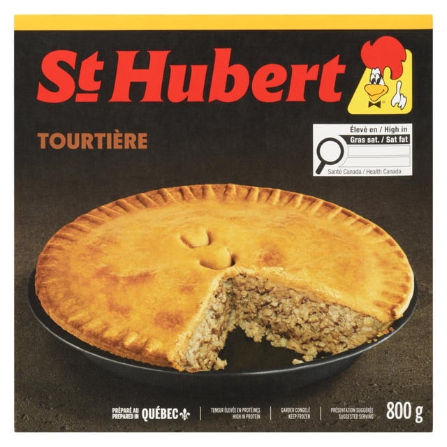 St. Hubert ST.Hubert Frozen Delicious Meat Pie, 800 g, with a golden-brown crust and a slice removed to show the seasoned pork and veal filling, displayed on a black plate, prepared in Quebec and labeled with Health Canada nutrition info, suitable for frozen storage and traditional meals.