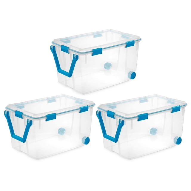 Sterilite Bac de Rangement Empilable à Roulettes de 120 Qt avec Couvercle, Lot de 3. Ensemble de Trois Bacs de Rangement en Plastique Transparent avec Poignées à Loquet Bleu aqua et Couvercles à Joint Scellé. Chaque Bac Comprend Deux Roues Arrière et une Poignée de Traction Rotative pour un transport Facile. La Conception Transparente Permet une Visibilité du Contenu, Tandis Que les Loquets Durables et le Joint d'Étanchéité Protègent contre l'Air, l'Humidité, la Poussière et les Insectes. Idéal pour Organiser les Vêtements Saisonniers, les Fournitures d'Artisanat Ou les Souvenirs dans les garages Ou les sous-