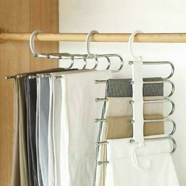 New American pants rack 5in1 stainless steel multi-function wardrobe magic hanger featuring five hanging rods with retractable design. The rack is shown in a horizontal position with multiple pairs of pants neatly organized. Made of ABS and stainless steel, it includes two hooks for horizontal or vertical hanging to save space. Dimensions are 33x16x15 cm, and the color is white.