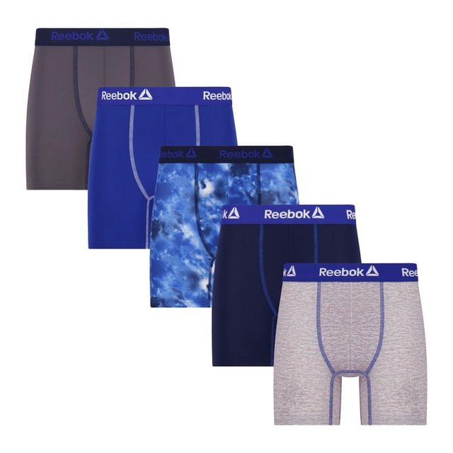 Reebok Boys' 5 Pack Performance Boxer Briefs shown in five colors: grey, solid blue, blue tie-dye, navy, and light grey with blue stitching. Each pair features an elastic waistband with Reebok logos, contour pouch for support, and soft stretch fabric for comfort and fit, ideal for active wear.