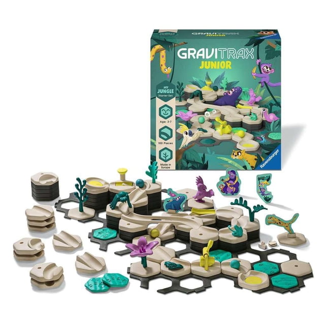 Ravensburger GraviTrax JUNIOR Starter-Set with jungle-themed marble run pieces including beige height tiles, green baseplates, animal figures, and decorative elements arranged in front of the box, an interactive STEM toy for children ages 3 to 7 that encourages creative building and problem-solving.