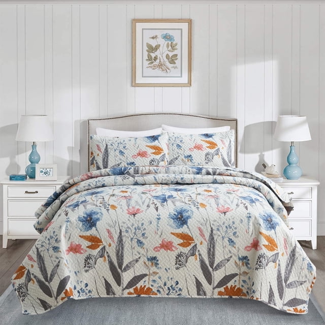 JML Ensemble de Courtepointe Florale, 3 Pcs, Format Très Grand en Bleu, Exposé sur un Lit Soigneusement Conçu dans une Chambre Éclatante. la Courtepointe Présente un Motif Floral vibrant avec des accents Bleu, orange et Rose sur un Fond Clair. Comprend une Courtepointe Mesurant 92x104 Pouces et Deux Cache-Oreillers Assortis Mesurant 20x36 Pouces. Fabriquée en Microfibre 100 % Douce et Respirante avec Rembourrage en polyester 140 G/m2 pour une Chaleur et un Confort Légers. la Chambre Est Stylée avec des Meubles Blancs, des Lampes Bleues et un art Mural Floral