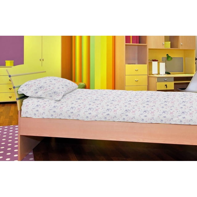Johnson Home 200 TC Bed Sheet Set - Printed Cotton Sheets on a single wooden bed with light natural finish, featuring white sheets and pillowcases printed with small purple and pink floral patterns, in a colorful bedroom with yellow and green striped walls and matching yellow furniture.