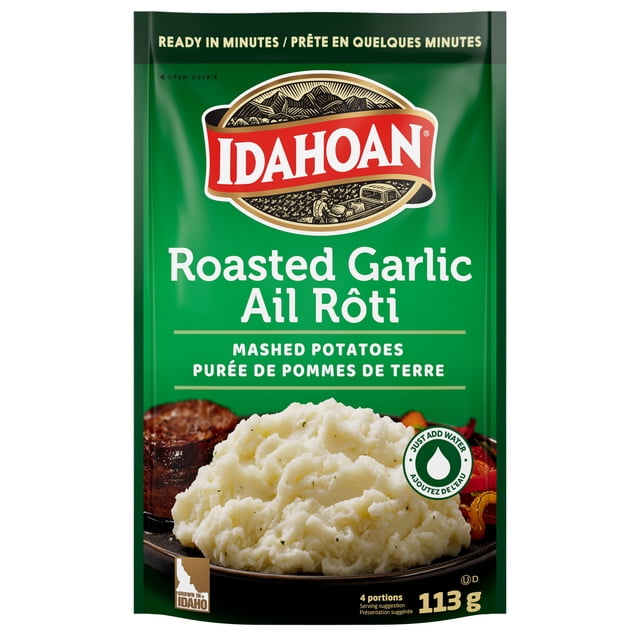 Idahoan Roasted Garlic Mashed Potatoes package with green background showing 113 g of instant mashed potatoes made from 100% real Idaho potatoes blended with roasted garlic and parsley, ready in minutes, suitable as a quick and flavorful potato side dish.