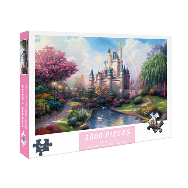 Jigsaw Puzzles for Adults Kids 1000 Pieces featuring a vibrant 'Dream Castle' design. The puzzle box displays a colorful castle surrounded by lush gardens, a serene pond with swans, and a rainbow in the background. The finished puzzle measures 29.5 x 19.69 inches (75 x 50 cm) and is suitable for ages 14 and up. Made from high-quality recycled cardboard with a special surface film for long-lasting color. Includes a high-definition reference poster and lettered zones on the back for easier assembly. Ideal for family bonding, intellectual development, and as a thoughtful gift for birthdays or holidays.