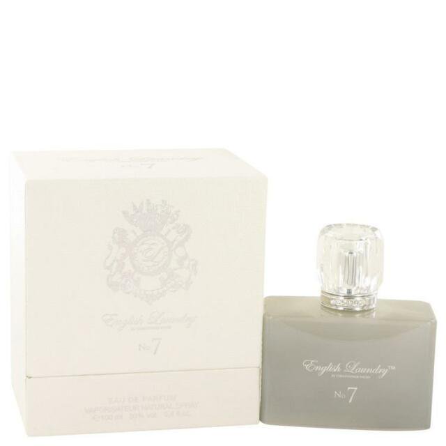 English Laundry No. 7 By English Laundry Eau De Parfum Spray 3.4 oz. The image shows a rectangular perfume bottle with a frosted grey finish and a clear, faceted cap, placed next to its matching cream-coloured box featuring an embossed crest design and elegant typography.