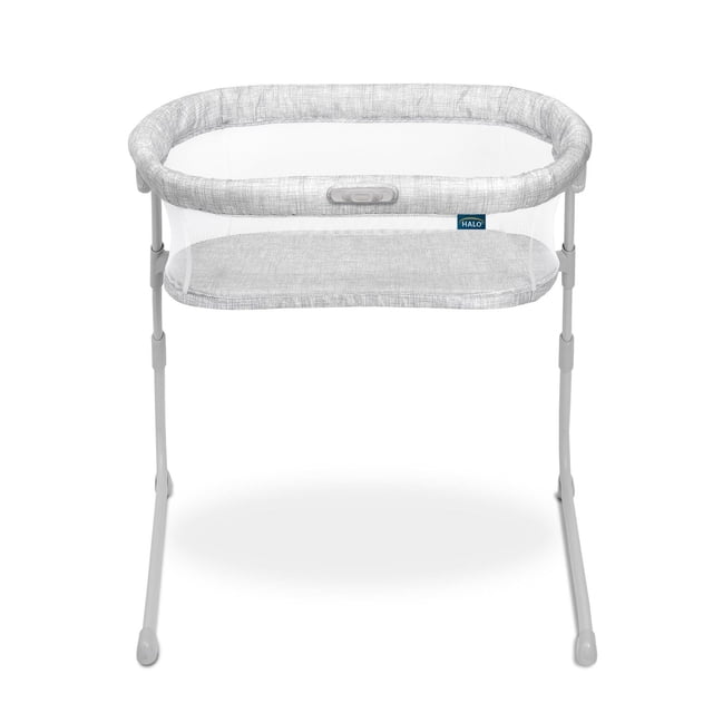 HALO® BassiNest® Flex™, portable baby bassinet bedside sleeper in light grey with breathable mesh walls, oval frame, adjustable height legs, and a lowering bedside wall lock for easy access, designed for safe sleep and convenient room-to-room use.