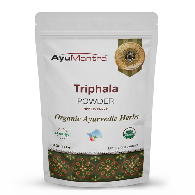 AyuMantra Triphala Powder, a 114g package of organic Ayurvedic herbs, featuring a blend of Amalaki, Bibhitaki, and Haritaki. The front-facing view of the resealable pouch highlights the product name, NPN 80143729, and certifications such as USDA Organic and OneCert. The packaging includes a decorative design at the bottom and emphasizes its use for digestive cleanse, detox, and antioxidant support.