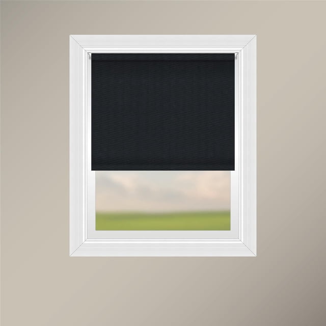 Off Cut Shades Chainless Blackout Roller Shade-Granite shown partially lowered in a white window frame, featuring black 100% polyester fabric with a sewn pocket and weighted hem for a clean finish, mounted on a sturdy white aluminum headrail, designed to block 100% of light with chainless operation for child and pet safety.