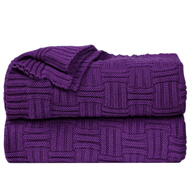 Unique Bargains 100% Cotton Cross Cable Knit Throw Blanket in purple, measuring 47 x 70 inches (120 x 180 cm). The blanket features a cross cable knit pattern with a soft and breathable texture, made from 100% natural cotton. It is lightweight and suitable for use on sofas, couches, beds, or as a travel or air conditioning blanket. The tightly knit weave ensures durability and shape retention after washing. The blanket is folded neatly, showcasing its intricate design.