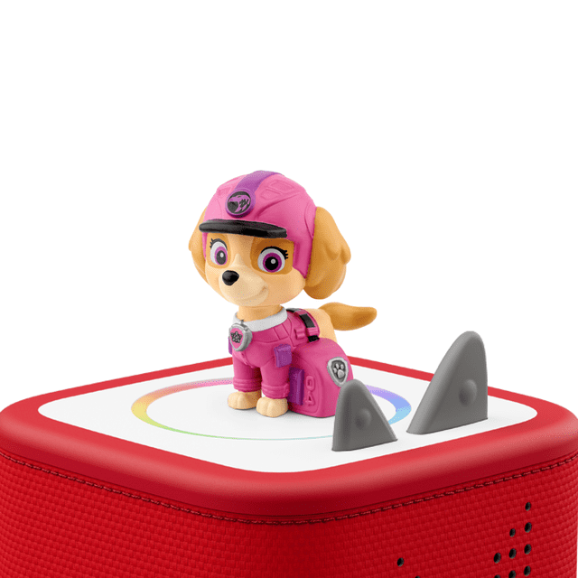 PAW Patrol Jungle Pups: Skye Tonie action figure in pink aviator outfit with helmet and badge, standing on a red Toniebox audio player with white top and grey ears, ideal for screen-free storytelling and imaginative play.