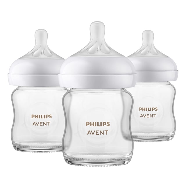 Philips Avent Glass Natural Baby Bottle with Natural Response nipple, 4oz, 3 pack, featuring three clear borosilicate glass bottles with wide white breast-shaped nipples that mimic breastfeeding, equipped with anti-colic valves and no-drip design for natural feeding rhythm.