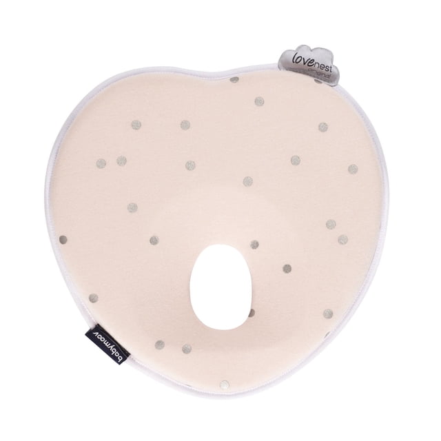 Babymoov Lovenest Pinkie infant head support pillow in soft pink with silver polka dots, heart-shaped with a central hole to relieve pressure on the back of the skull, made from breathable organic cotton with white trim and branded tags, compatible with strollers, swings, and bouncers for ergonomic baby support.