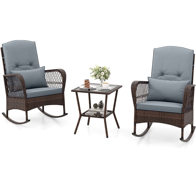 Patiojoy 3 Pieces PE Rattan Rocking Bistro Set featuring two mix brown PE rattan rocking chairs with gray cushions and lumbar pillows, and a 2-tier coffee table with a tempered glass top and lower storage shelf. The chairs have curved armrests and high backrests for comfort, while the table provides a stable surface for drinks and snacks. Ideal for outdoor spaces like porches, gardens, and poolside areas.
