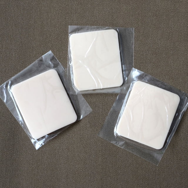 Radiant Saunas 3 pack Infrared Sauna Oxygen Ionizer Fragrance Pad Replacement with three individually wrapped white square pads sized 1.75 by 2.125 inches on a brown textured surface, designed to purify and freshen sauna air by eliminating odors and bacteria for improved sauna experience.