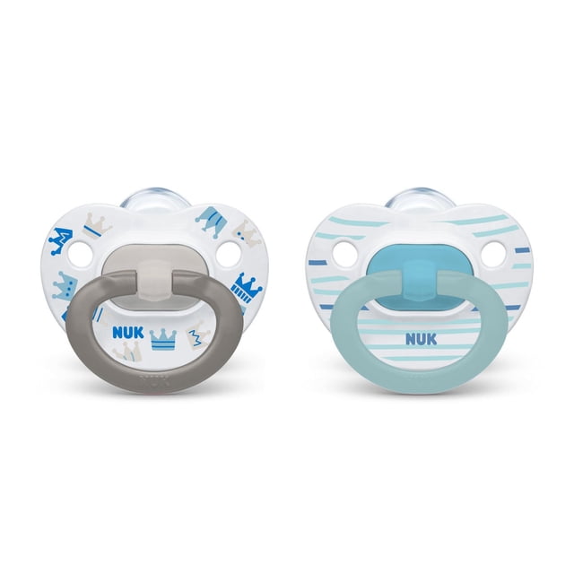 NUK Suces Orthodontiques, Lot de 2 pour Bébés de 6 à 18 Mois, avec Tétines Asymétriques en silicone pour Réduire la Pression de la Mâchoire. une Sucette a un Bouclier Blanc avec Motifs de Couronne Bleu et beige et une Poignée Grise, l'Autre a des Rayures Bleues sur un Bouclier Blanc avec une Poignée Bleu Pâle.