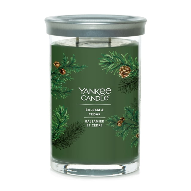 Yankee Candle Scented Candle, Balsam & Cedar, 20 oz Signature Large Tumbler with green soy wax in a clear glass container featuring hand-illustrated balsam and cedar branches with pinecones on the label, topped with a brushed tin lid that doubles as a coaster, containing two cotton wicks for a clean burn, suitable for creating a calming forest atmosphere in home décor.
