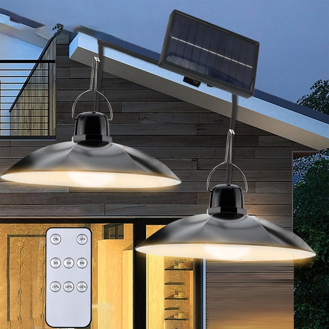 Vaidha Double Heads Solar Pendant Light with two black pendant lamps featuring wide circular shades, illuminated in warm light. A solar panel is mounted above, connected by wires for solar-powered operation. Includes a remote control for brightness adjustment and timer settings. IP44 weatherproof design ensures durability for outdoor and indoor use, ideal for gardens, patios, or entryways.