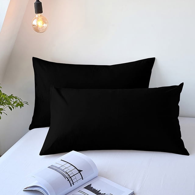 Staron Cooling Pillow Cases Queen Size Set of 2 in black, made of soft brushed microfiber polyester. These breathable and temperature-regulating pillowcases are designed for hot sleepers, offering relief from night sweats and overheating. Featuring an envelope closure for secure fit, they measure 48x74cm and are suitable for all seasons. Displayed on a white bed with a minimalist background.