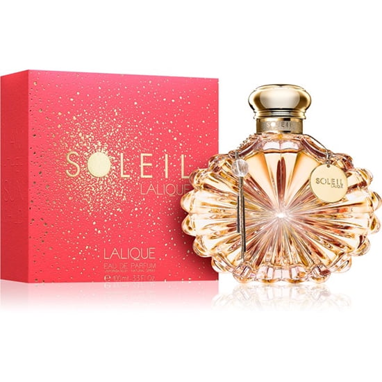 Lalique Soleil by Lalique Eau De Parfum Spray 3.3 oz / 100 ml for women, a luxury fragrance in a sunburst-inspired glass bottle with gold accents and a charm. The perfume is paired with vibrant red packaging featuring gold detailing, ideal for women's fragrance collections.