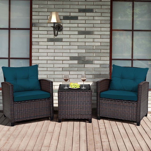 Costway Ensemble de Mobilier de Patio en Rotin 3 Pcs, Ensemble de Conversation Rembourré, Sofa Bleu. Comprend Deux Fauteuils en Rotin avec Coussins Bleus et une table Basse Carrée avec Dessus en Verre Trempé. Idéal pour les Installations de Mobilier de Patio Extérieur, Tels Que les Jardins, les porches Ou les Zones au Bord de la Piscine. Exposé sur un Patio en Bois avec un Fond de Mur de Briques.