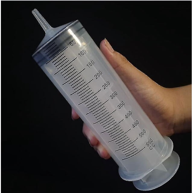 Syringe 500 Ml Large Capacity Syringe Reusable Pump Measuring With 1m Tube Feeding Ink. A clear, industrial-grade 500ml plastic syringe with precise measurement markings, designed for fluid dispensing. The syringe features a durable, chemical-resistant body and a large nozzle for efficient fluid management. Held against a dark background, the syringe is shown in a hand for scale.