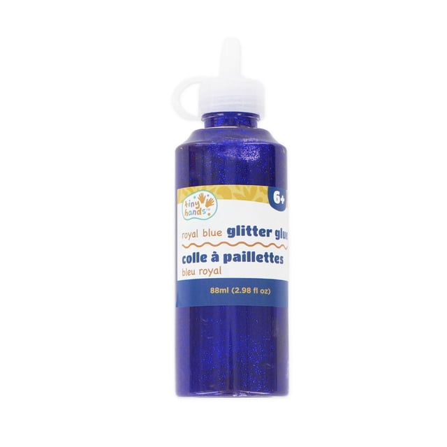 TINY HANDS Royal Blue Glitter Glue in an 88 ml (2.98 fl oz) squeezable bottle with a pointed white cap, suitable for kids aged 6 and up to add sparkling adhesive effects to scrapbooking, paper crafts, and decoration projects.