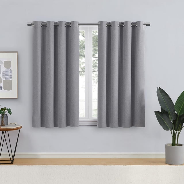 Eclipse Corte Panneau de Rideaux Occultants à Oeillets de 63 Pouces pour Fenêtre en Flanelle Grise, Suspendu sur une Tringle Métallique Argentée dans une Pièce avec des Murs Gris Pâle, Plancher en Bois, une table d'Appoint avec une Plante et des Verres, et une Plante Verte en Pot, Doté d'Un Tissu Occultant pour le Contrôle de la Lumière, la Réduction du Bruit et une Intimité Totale.