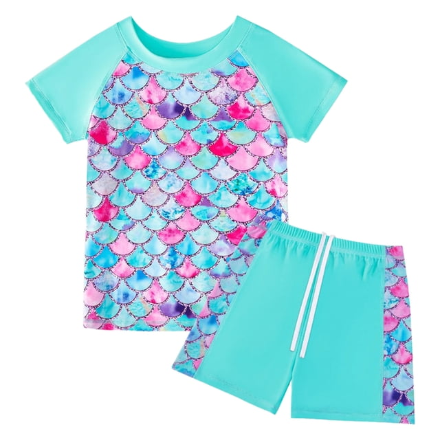 PMVFHDE Girls Scale Print Swim Set featuring a short sleeve rash guard and swim shorts in sky blue, designed for kids aged 5-6 years. The top showcases a vibrant scale print in shades of pink, blue, and purple, while the shorts are solid sky blue with matching scale print accents on the sides. Made from polyester, this two-piece bathing suit offers UV protection and is suitable for swimming and beach activities.
