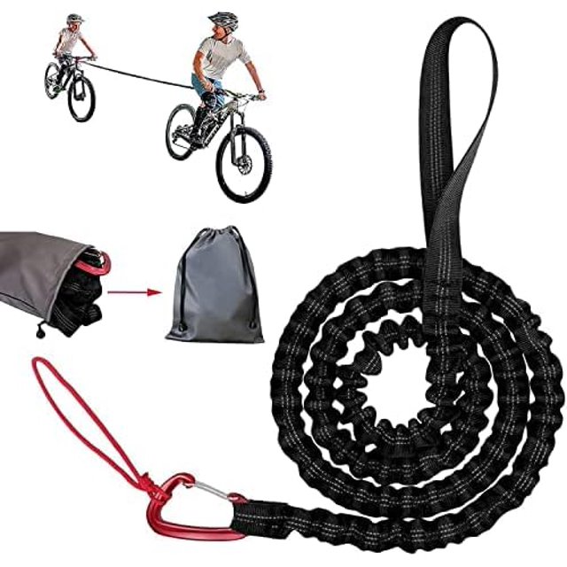 3 m arent Child Pull Rope Stretched Elastic Pull Rope with Safety Hook, up to 500 lb/225 kg. A durable black nylon tow rope with a red metal safety hook, designed for towing children's bicycles. The rope is shown coiled and extended, with a demonstration of its use between two bicycles. Includes a compact polyester storage bag for portability.
