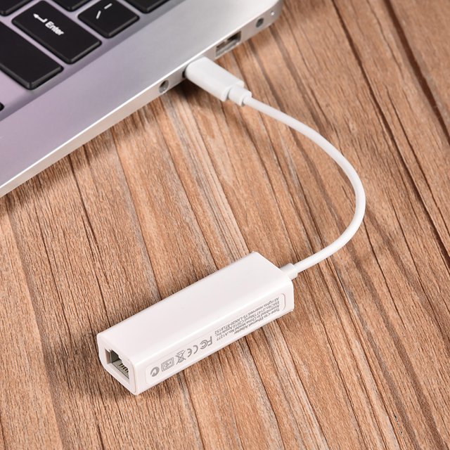 Adaptateur USB-C vers Ethernet par Walfront, Doté d'Une interface Ethernet Usb 3.1 Type-C vers RJ45 avec une Vitesse de transmission Maximale de 100 Mbps. l'Adaptateur compact Blanc Est Connecté à un Ordinateur portable via Son port Type-C, Montré sur une surface en Bois. Il Comprend une Puce 8152B Avancée pour des Performances Stables et une Grand Compatibilité avec Windows XP/7/8 et Autres Systèmes d'Exploitation. la Longueur du Câble Est d'Environ 12 cm, et l'Adaptateur