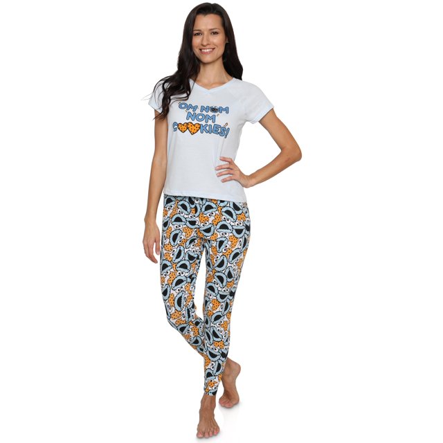 Sesame Street Ensemble de Pyjama pour Femme à Manches Courtes et Pantalon de Détente Comprenant une Chemise Blanche à Col en V à Manches Courtes avec Cookie Monster et le Texte « OM Nom Nom Biscuits » sur la Poitrine, Assorti à un Pantalon de Détente Mettant en Valeur un Motif Ludique de Visages de Cookie Monster et des Biscuits en Forme de Cœur. Fabriqué à Partir d'Un Mélange de Coton/polyester/Spandex pour le Confort, l'Ensemble Comprend une Taille Élastique pour un Ajustement Sécuritaire. Tenue de Détente Sesame Street sous Licence Officielle, Idéale pour les fans de Cookie Monster et des Vêtements de Nuit Douillets.