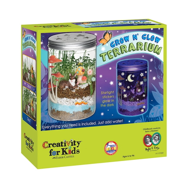 Creativity for Kids Grow N' Glow Terrarium Arts and Crafts for Children, featuring a plastic mason-style jar approximately 5 inches tall and 3.25 inches wide. The kit includes potting mix, organic chia and wheat grass seeds, decorative sand, river stones, garden figurines, and a plant mister. The jar is decorated with translucent and glow-in-the-dark stickers, creating a vibrant and interactive habitat. The packaging highlights the multicolour design and glow-in-the-dark feature, suitable for children aged 6 and up.