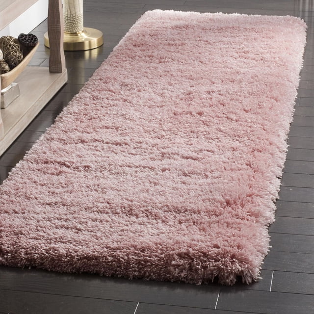 SAFAVIEH Polar Abbot Tapis Shag en Peluche Extrême Uni en Rose Doux avec un Poil Épais de 3 Pouces, Posé sur un Plancher de Bois Franc Foncé Près d'Une Tablette en Bois Clair et d'Une base de Lampe en Laiton, Idéal pour Ajouter Chaleur et texture aux Espaces de Tapis Coureur.