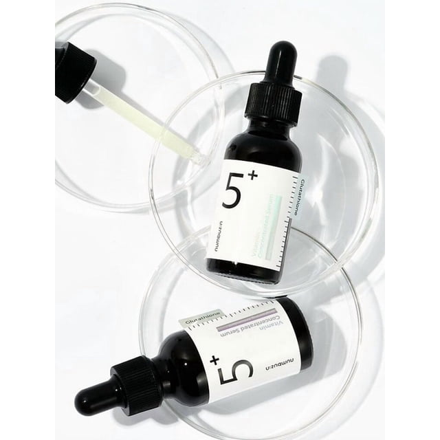 numbuzin No.5 Sérum Concentré à la Vitamine 30 ml en Deux Bouteilles Compte-Gouttes Noires Placées à l'Intérieur de Boîtes de Pétri Transparentes sur Fond Blanc, Présentant une Formule Légère et Non Grasse avec Vitamine C, Glutathion, Alpha-Arbutine et Niacinamide pour Illuminer et Unifier le Teint pour Tous les types de Peau.