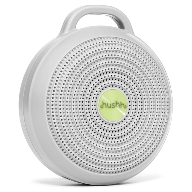 Yogasleep - Baby, Toddler - Hushh® Compact Sound Machine in grey, angled front view with circular perforated speaker grille and central green button labeled 'hushh', featuring a built-in handle for portability, designed to mask noise and support sleep training in nurseries.