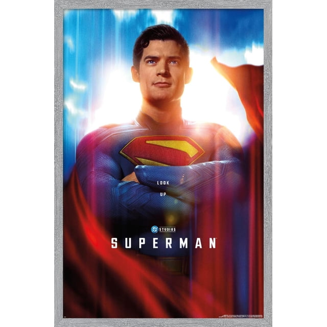 DC Studios Superman (2025) - Affiche Murale Gros Plan d'Une Feuille Montrant une Vue Centrée et Orientée vers l'Avant de Superman en Costume Texturé Bleu avec un Emblème « s » Rouge et Jaune sur la Poitrine, Bras Croisés, Encadrée d'Une cape Rouge Fluide et d'Un Fond Lumineux Bleu et Blanc Vifs, avec Texte « Regardez vers le Haut » au-Dessus du logo DC Studios et Titre « Superman » en Dessous, le Tout dans un Cadre Gris Pâle. Cette Affiche