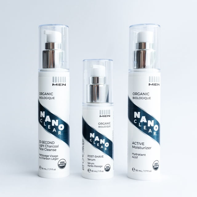 Nano Clear 3 Step System, a USDA organic skin care gift set with three products: charcoal gel cleanser, lightweight hydrating serum, and active moisturizer. Suitable for all skin types, including sensitive skin, with plant-based formulas for hydration, nourishment, and balance. Bottles are upright with clear pump dispensers and sleek white and navy packaging.