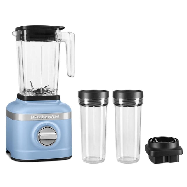 KitchenAid 3 Speed Ice Crushing Blender with 2 Personal Blender Jars in pastel blue, featuring a 48-oz clear blender jar with black lid and handle, a silver control dial with 3 speed settings plus ice crush, two clear personal blending jars with black lids for blending and on-the-go use, and a black blade assembly base.