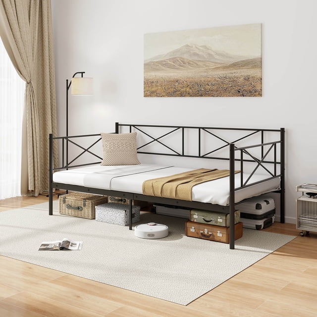 Gymax Lit Plateforme Moderne en Métal Format Simple Daybed Noir avec Lattes Métalliques Robustes, Présenté dans une Pièce Lumineuse et Minimaliste. The Daybed Présente un design en Forme de Croix sur le Dossier et les Accoudoirs, avec un Matelas Format Simple et une Couverture Jetée beige. Grand Rangement sous le Lit Est visible, Tenant Valises, Paniers et un Aspirateur Robotique. le Cadre Robuste Comprend 5 Pieds pour un Soutien Accru, et le Lit Est Surélevé de 10,5 Pouces du Sol, Offrant un Accès Facile pour le Nettoyage.