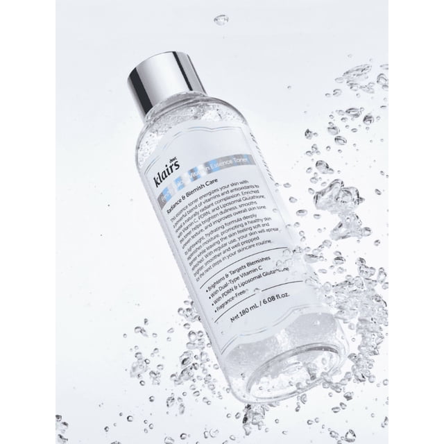 Dear, Klairs Lotion Tonifiante à l'Essence de Vitamine Fraîchement Jusée Bouteille de 180 ml avec un Bouchon Argenté Élégant, Entourée d'Éclaboussures d'Eau. la Bouteille Transparente Met en Valeur la Formule Légère et Riche en Vitamines Conçue pour une Hydratation en Profondeur et un Éclat. Convient aux Peaux Sensibles, Sèches, Grasses Ou Mixtes, Ce Toner Végane et Sans Cruauté Offre une Livraison en Microcapsules d'Ingrédients Actifs comme des Dérivés de la Vitamine C et des Acides Hyaluroniques pour un Teint Éclatant.