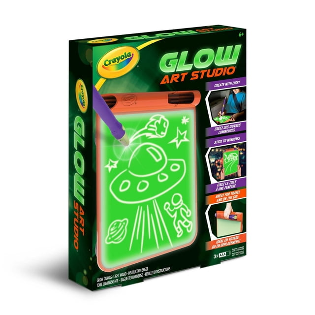 Crayola Glow Art Studio with an 8.5 by 10 inch glow canvas displaying a glowing drawing of a UFO, astronaut, stars, and planet made using the included purple light wand. The kit features suction cups to stick on windows and a handle for easy carrying, ideal for kids aged 6 and up and suitable for travel or sleepovers.