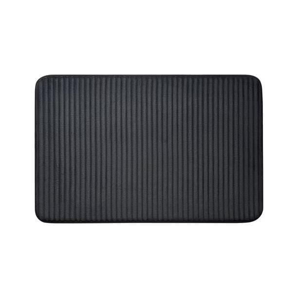 Mainstays Memory Foam Bath Mat in black with ribbed texture, measuring 20 by 30 inches, made of soft, absorbent polyester with cushioned memory foam and non-slip backing, ideal for bathroom floors and stepping out of the shower.