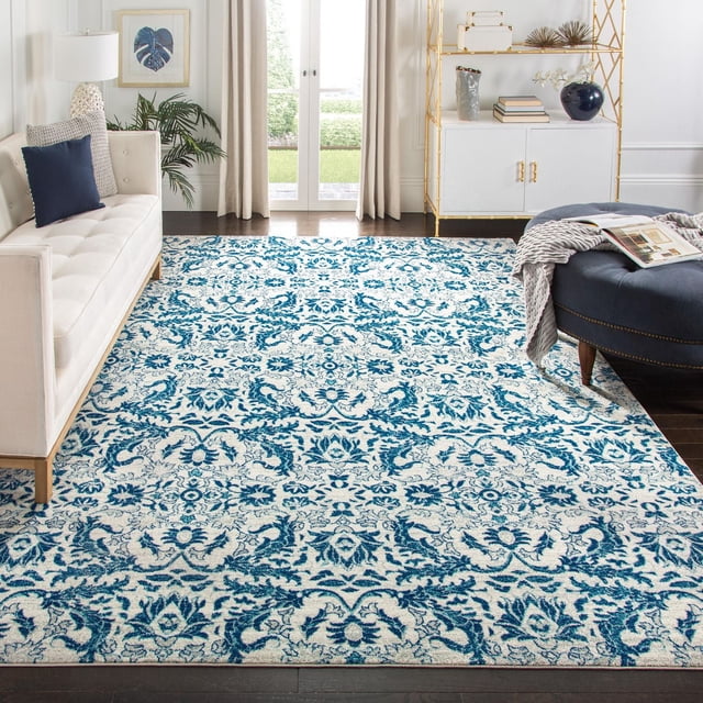 Safavieh Evoke Tapis Floral Ksenija pour Aire avec Motif Floral Bleu et Blanc et texture Douce de Frise à Poil Coupé Faite de Fils de Polypropylène Durables, Exposé dans un Salon avec sofa Blanc, ottoman Bleu Marine et Étagères Métalliques Dorées, Idéal pour une Utilisation Stylée comme Tapis d'Accent.